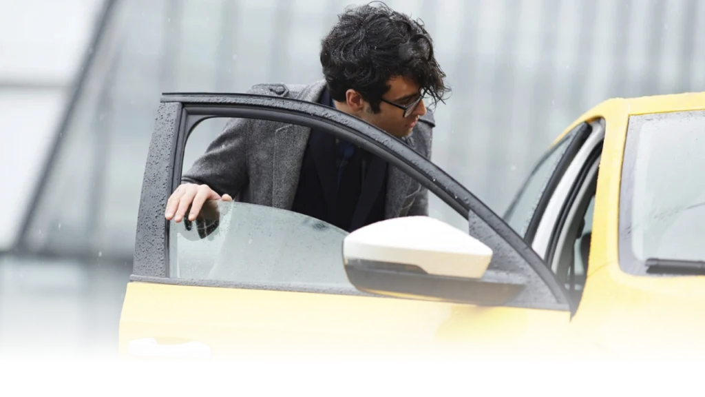 Homme entrant dans un taxi jaune.